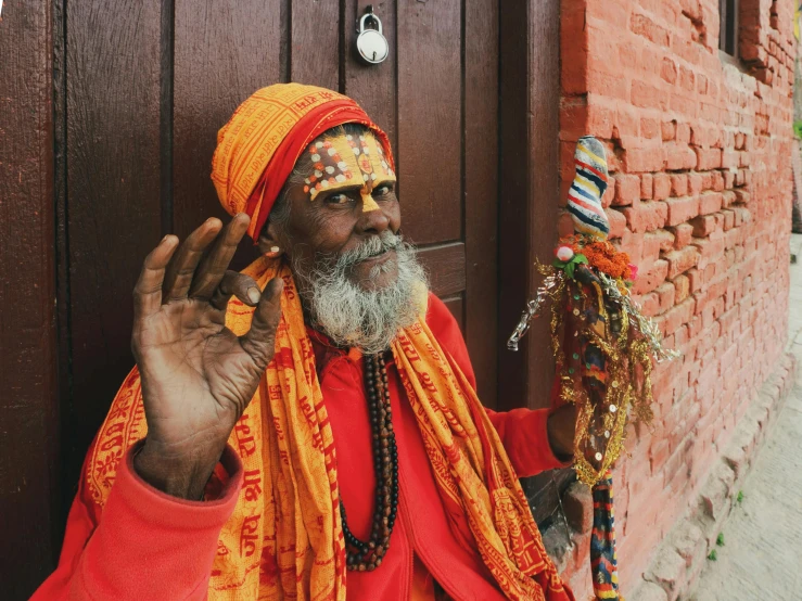 an old man in yellow sits holding a door