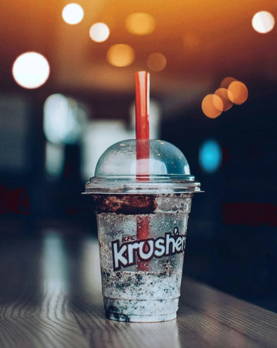 a cold drink with a straw sits on a table