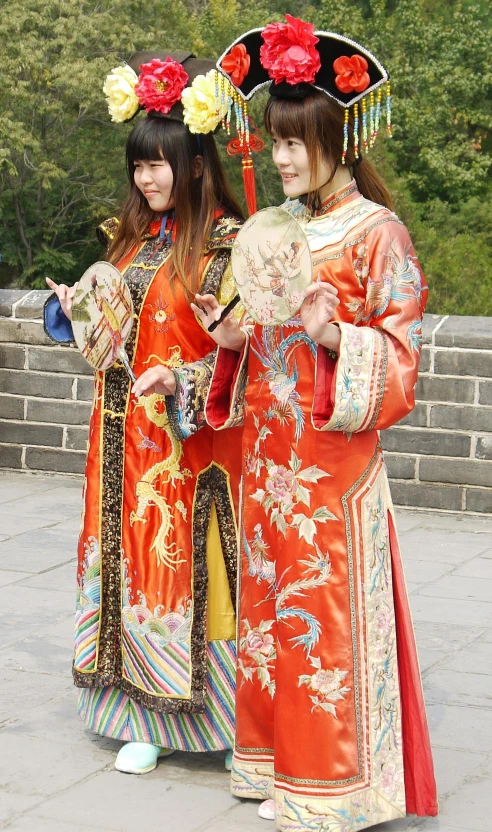 two japanese girls in traditional costume looking at their cell phone