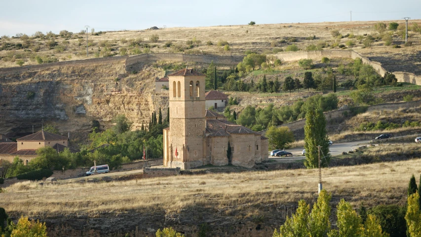 a church in a canyon by a road and some trees