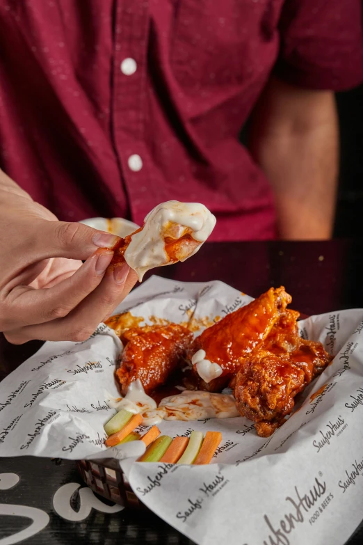 a man eating spaghetti with sauce in his hand