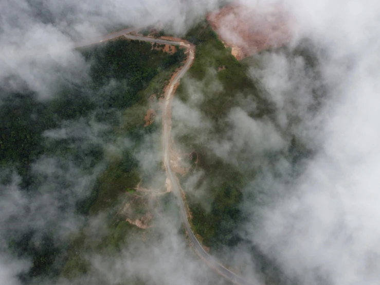 a road that is running through the clouds