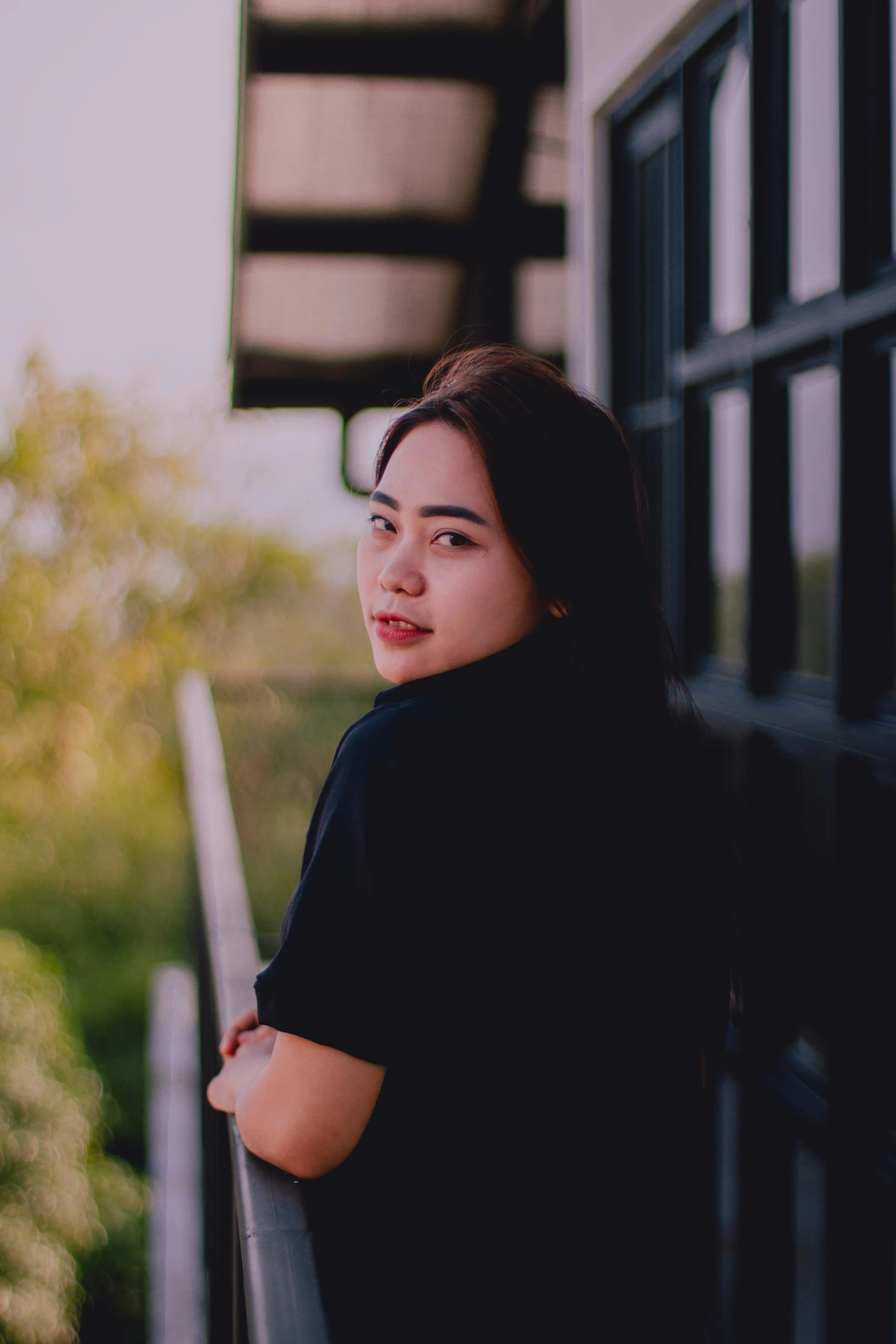 the woman is leaning against the railing looking back