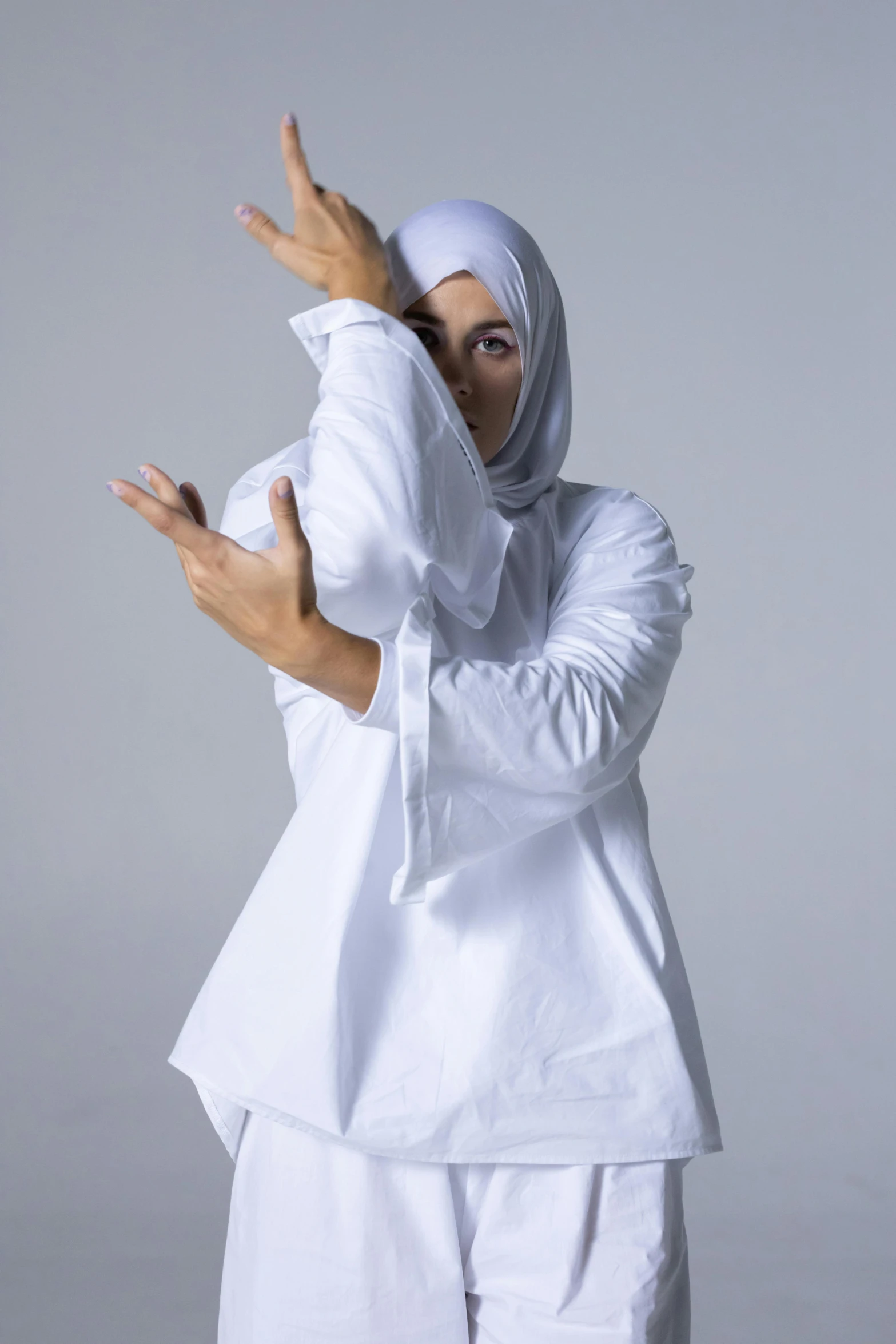 a woman wearing white clothes holding her hands out