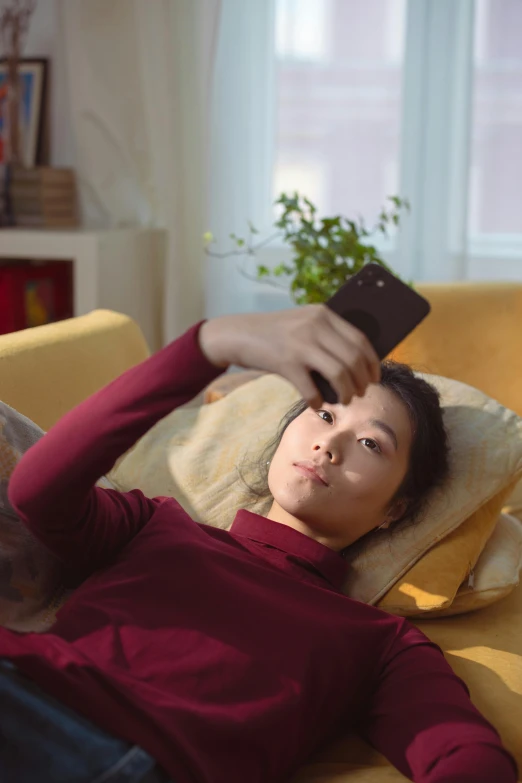 a man laying on his stomach while holding onto his cell phone