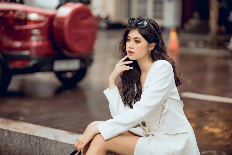 a woman in a white suit sits on some steps