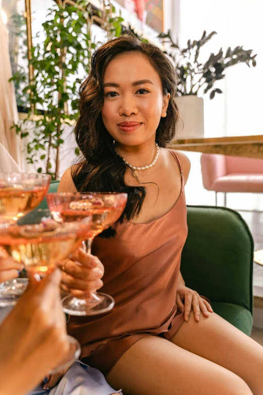 a woman sitting at a table with glasses of wine