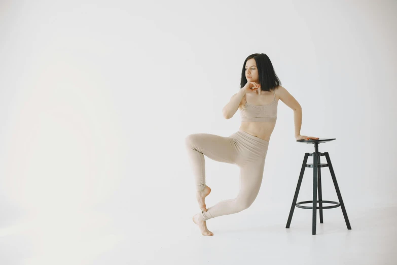 a woman poses on a stool in her underwear