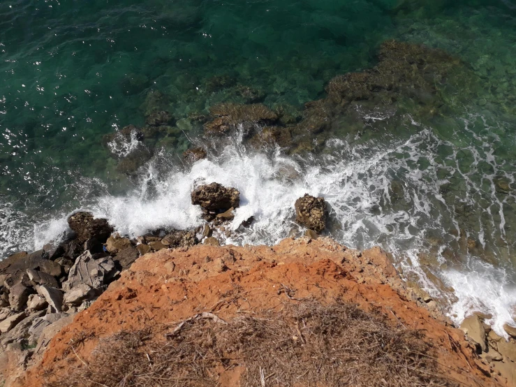 view of some water from above rocks and a shoreline
