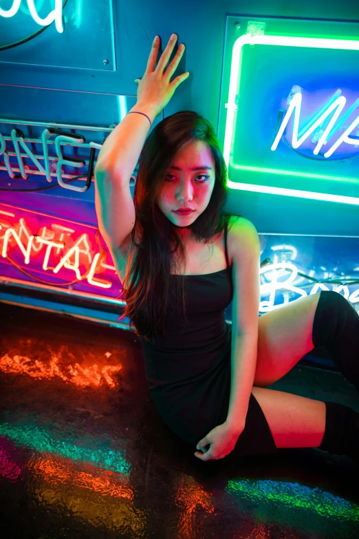 a young woman is posing for a picture with the neon sign