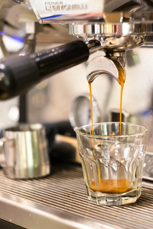 someone is using a coffee maker to make espresso