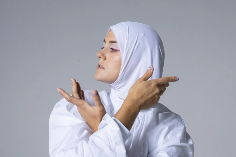 a woman in a white turban is holding her hands together