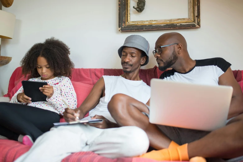 two people and a child are sitting on the couch