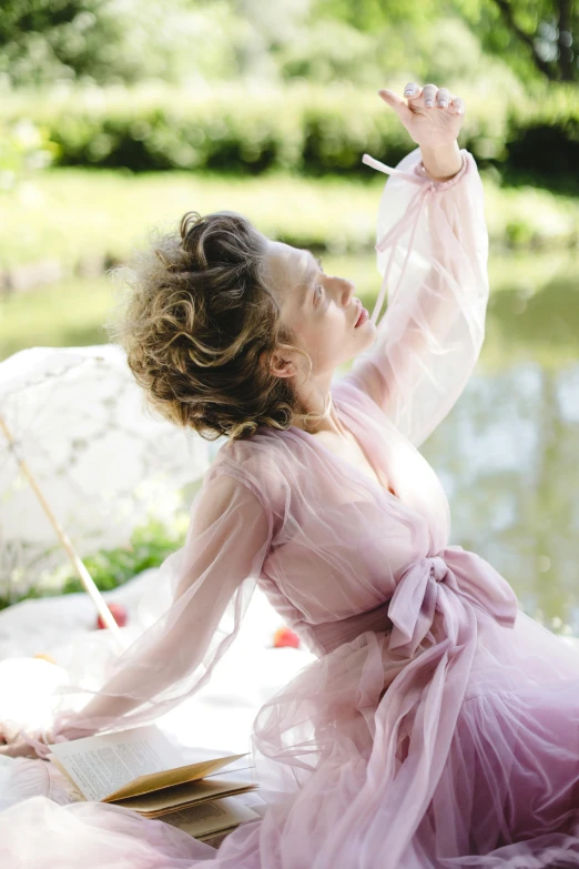 a woman in a dress holding an umbrella and reading