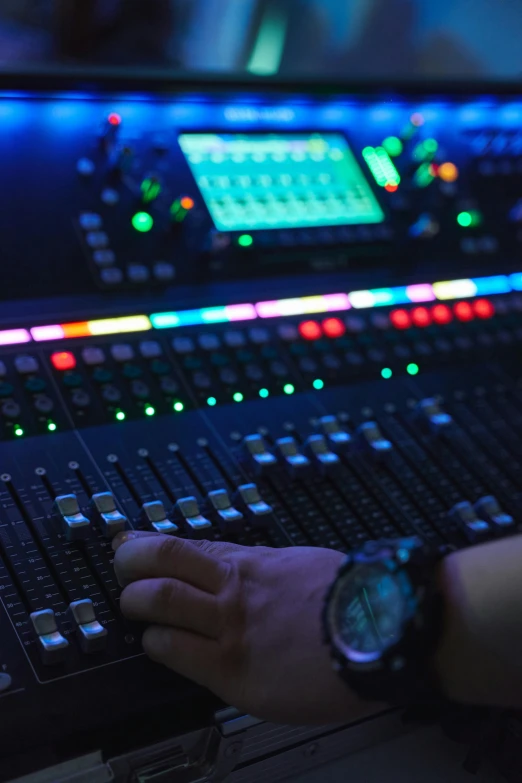 a man touching an analog mixing board