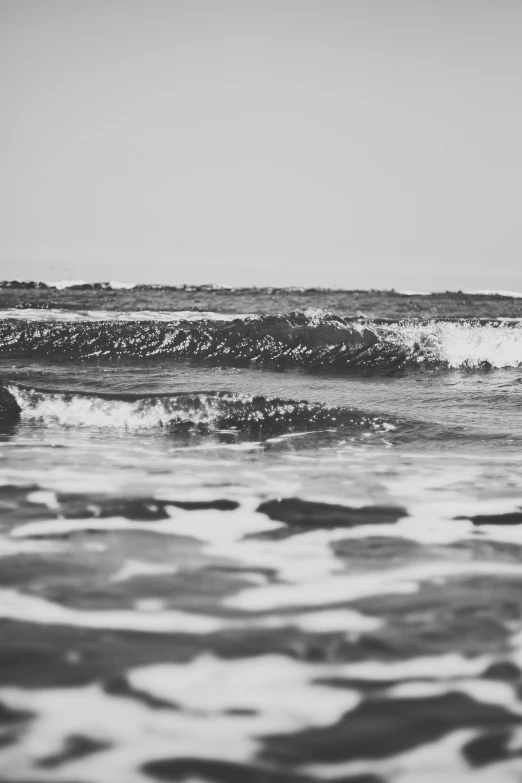 a person walking through some water while holding onto a surfboard