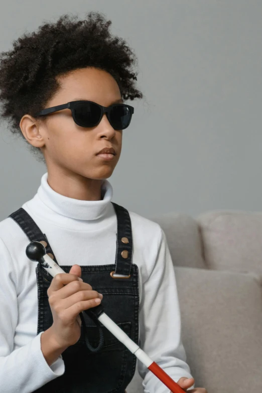 a small child wearing sunglasses holding an umbrella