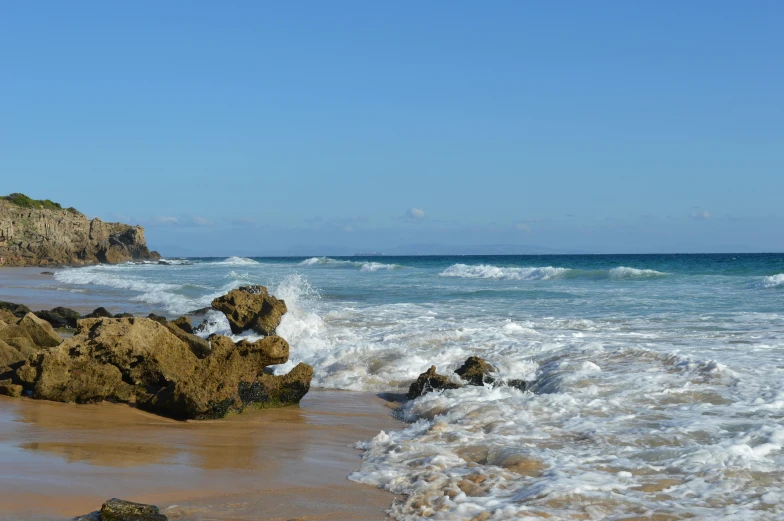 the waves are crashing against the rocky coast