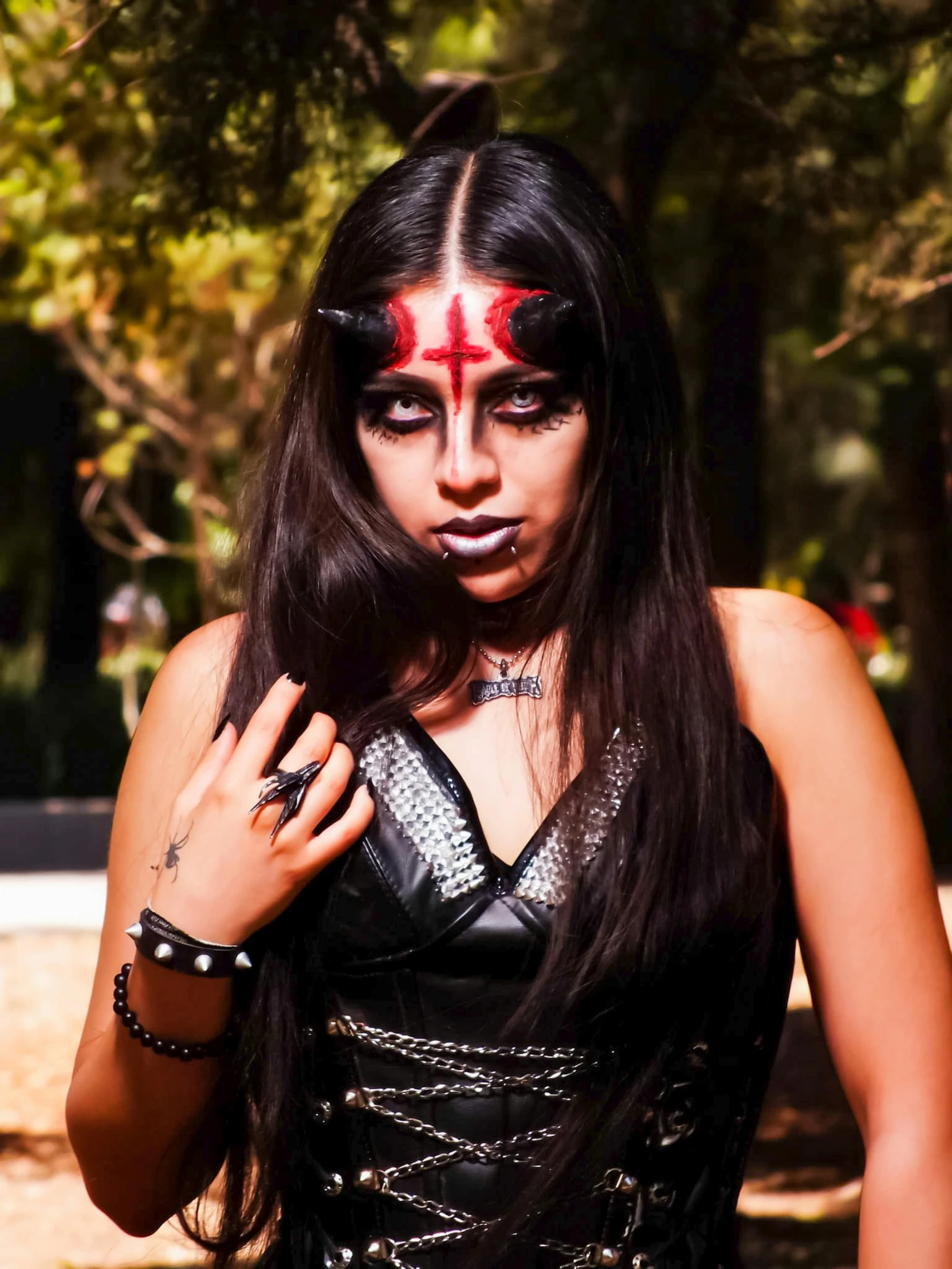 a woman in black latex and piercings with a cross