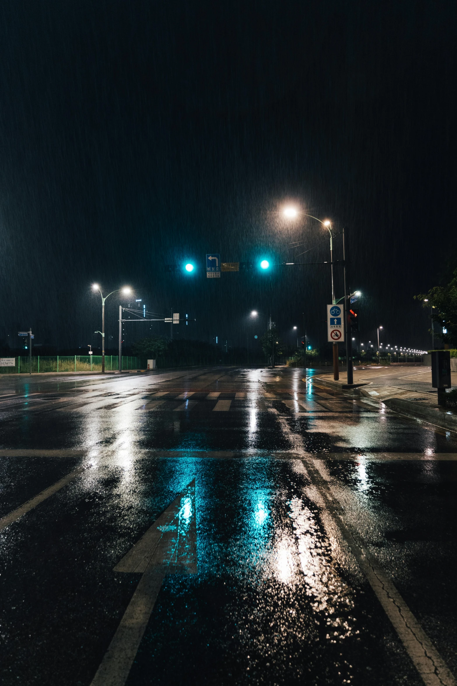 dark street at night with green traffic lights