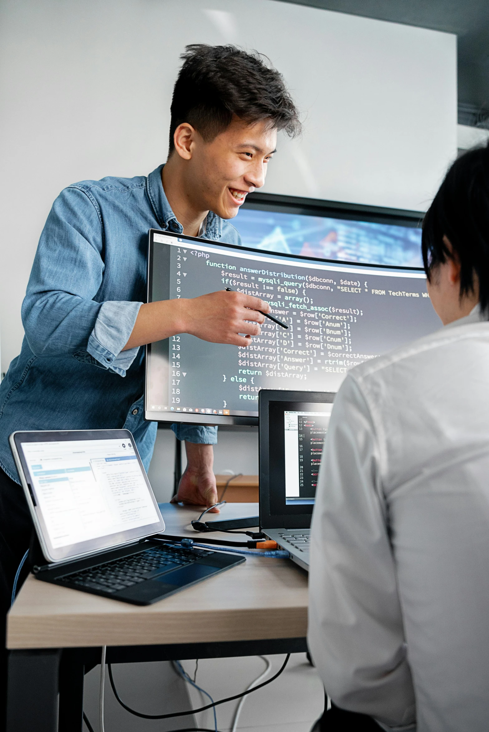 two men looking at laptops in a computer lab