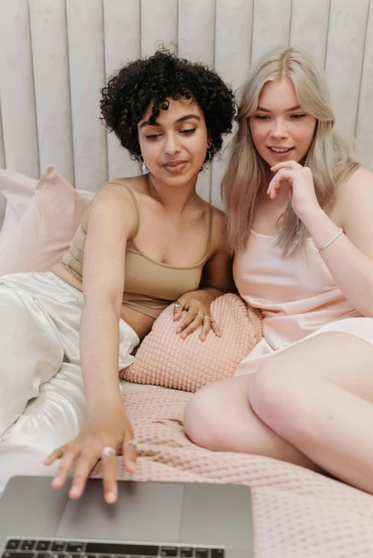 two women are sitting next to each other on the bed