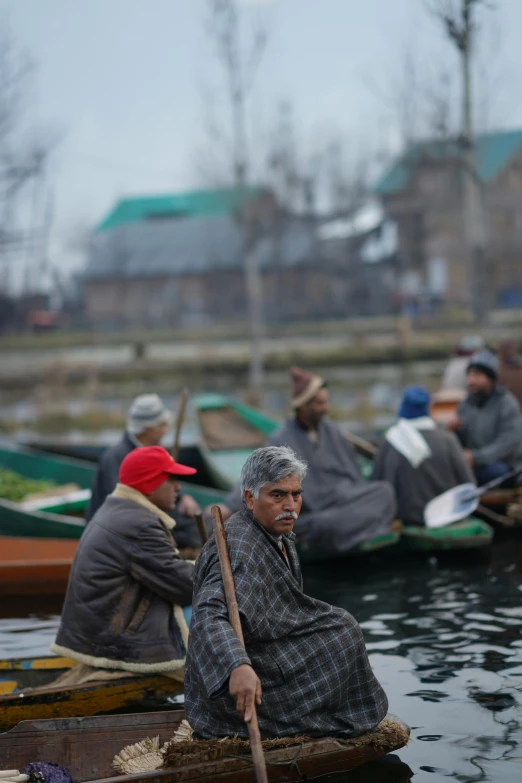 a group of people on wooden boats with paddles