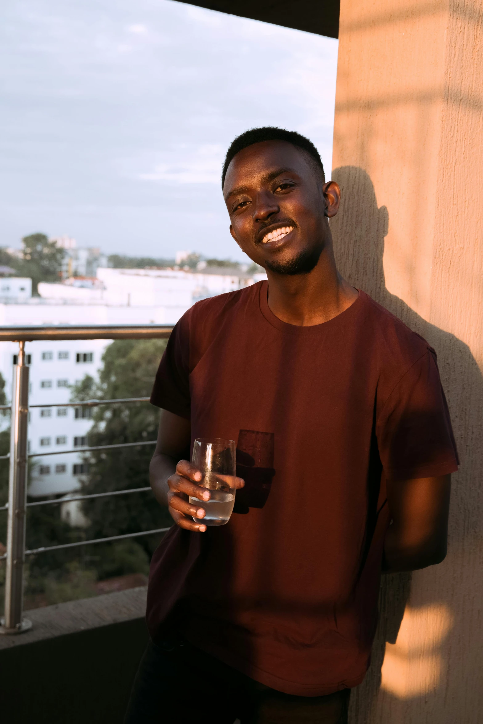 a man holding a glass on top of a roof