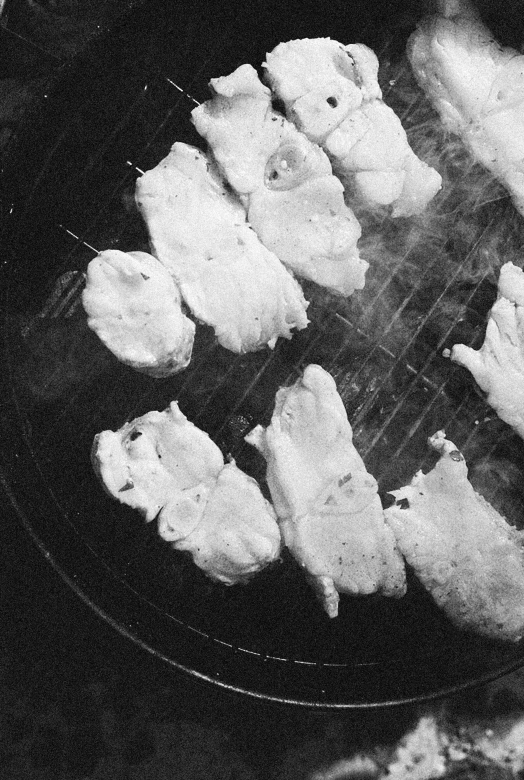 a grill topped with meat being cooked in a cooking pan