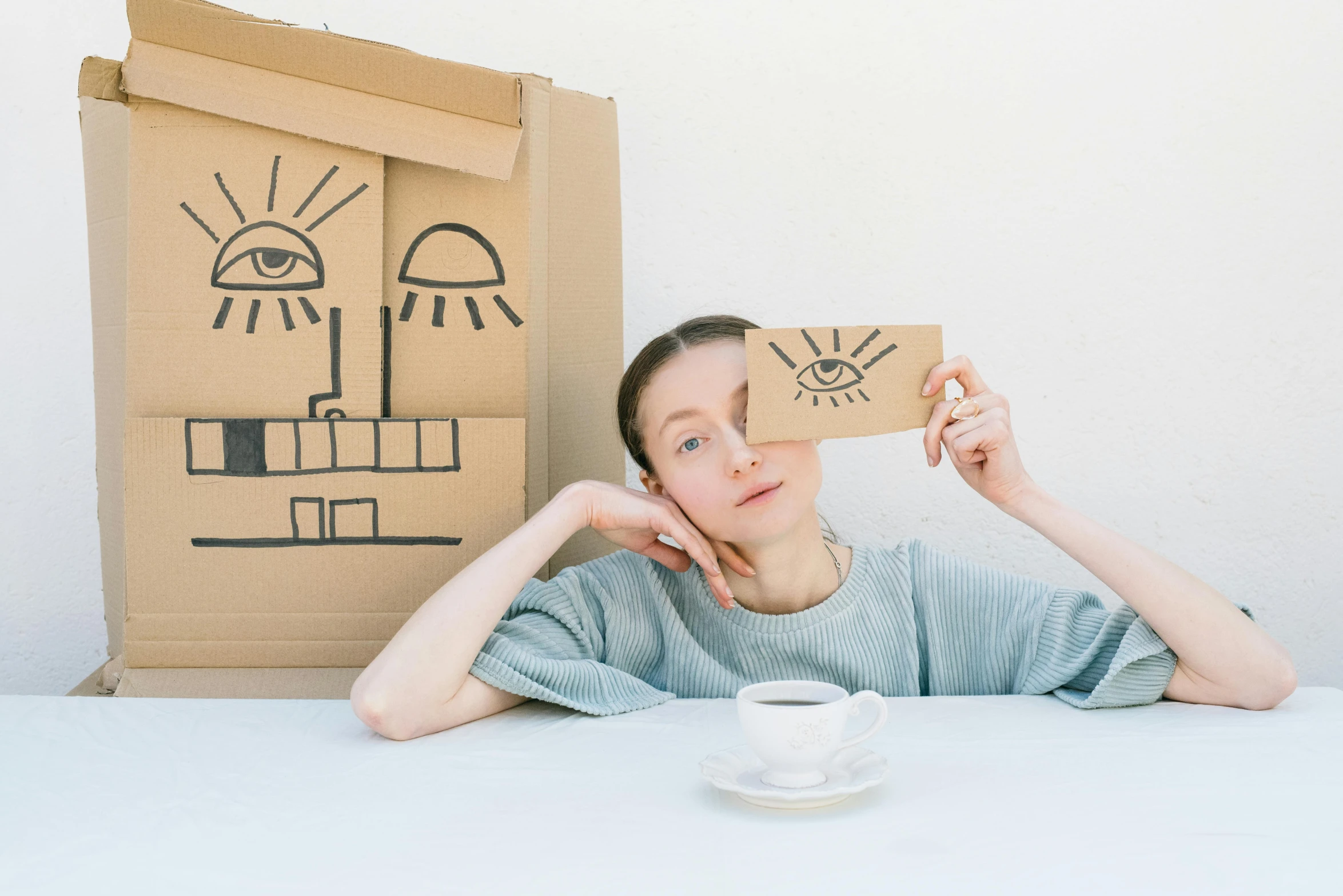 a girl sitting in front of boxes and a cup