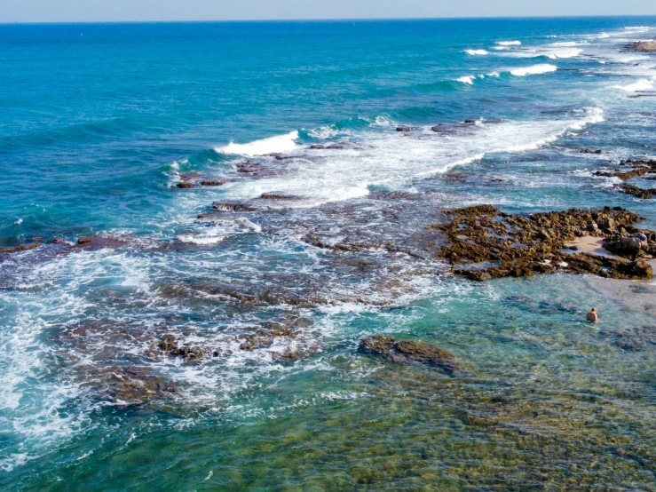 an aerial s of some sea rocks next to the water