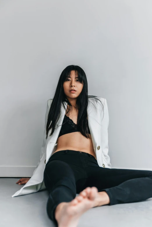 a woman laying on the floor next to a white wall