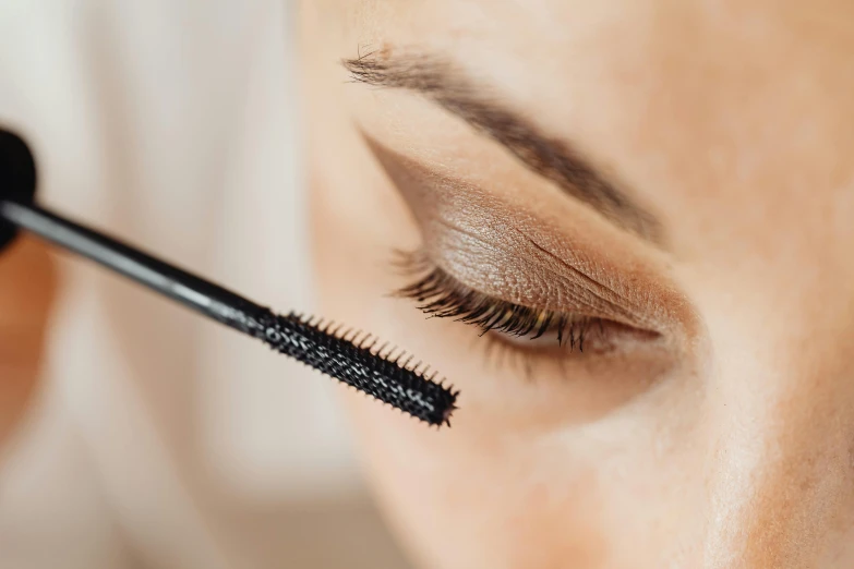 a woman with long lashes is doing her lashes