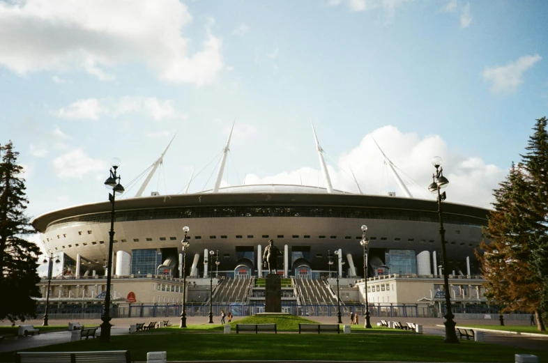 an olympic style building sitting on top of a lush green field