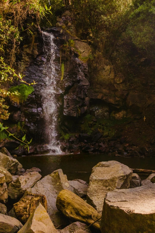 a person is sitting in the shade under the waterfall