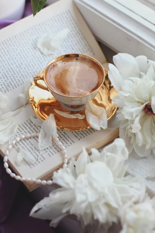 a table topped with a book next to a bouquet of flowers