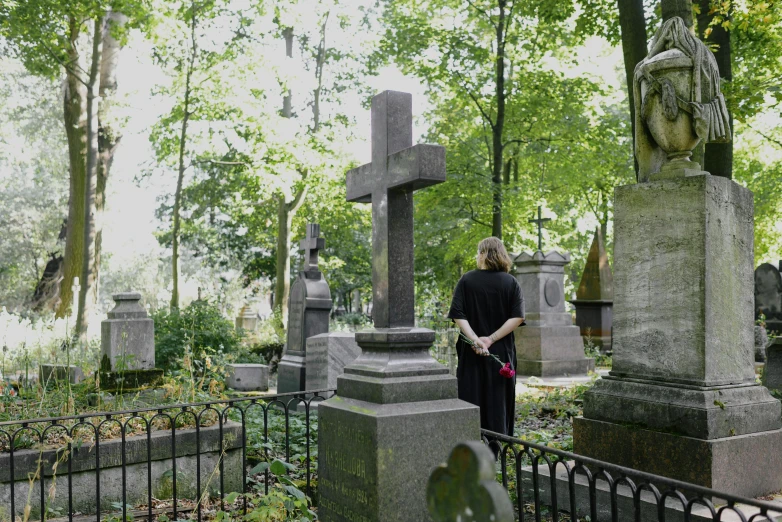 a woman is looking at an old cemetery