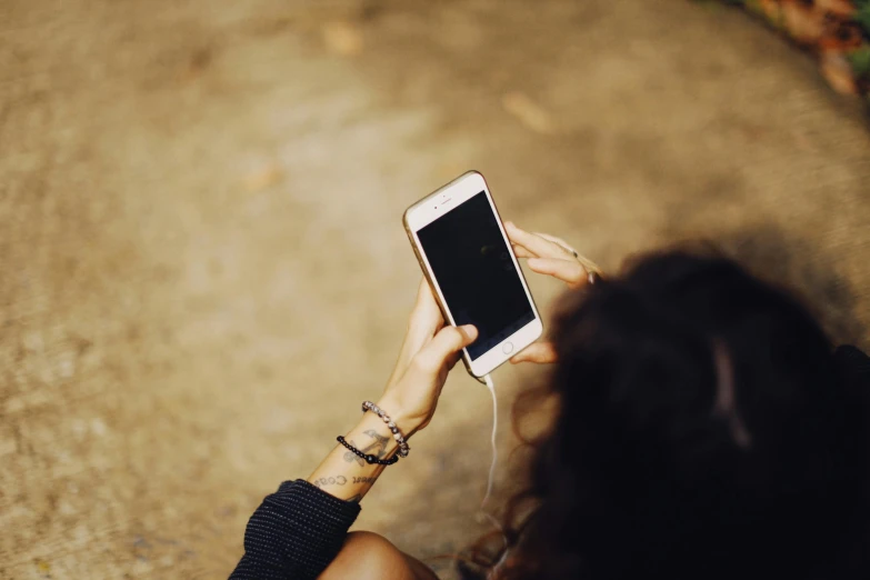 a person is holding a cell phone over their shoulder