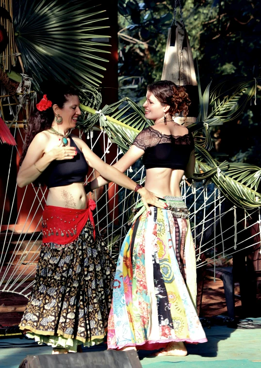 two women are dressed up in colorful outfits and hula hoops