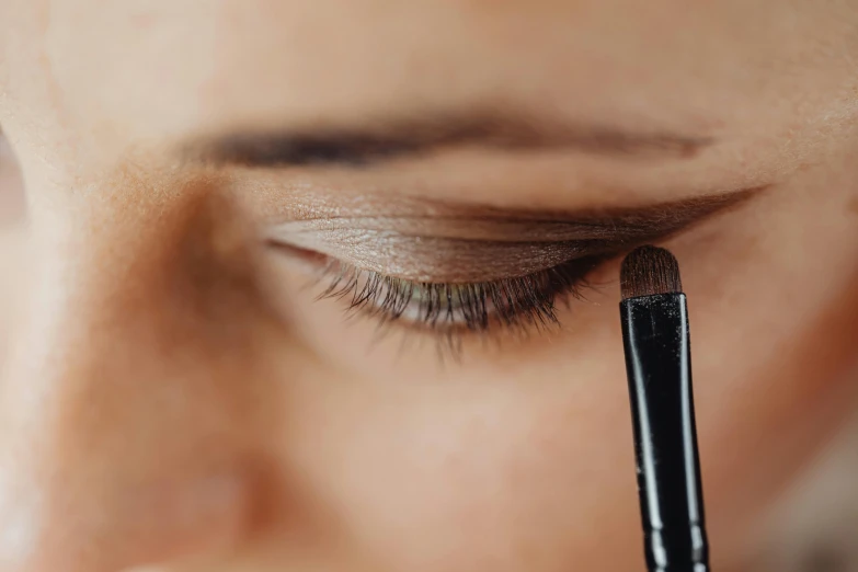 a woman's eyelashes are closed and she has the brushes inside her