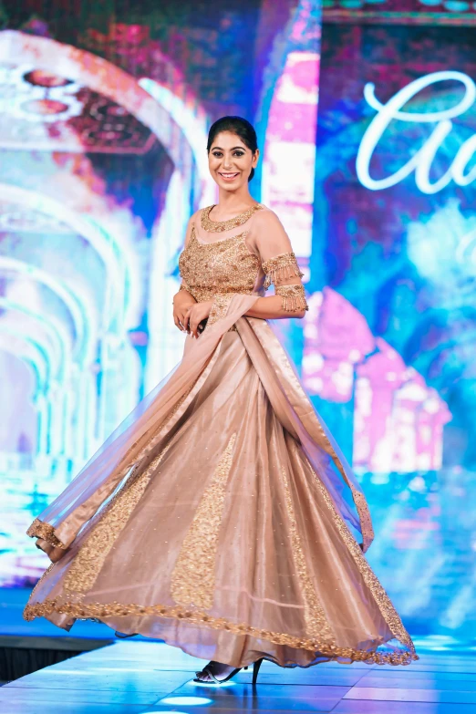 a beautiful indian woman in a dress on the ramp