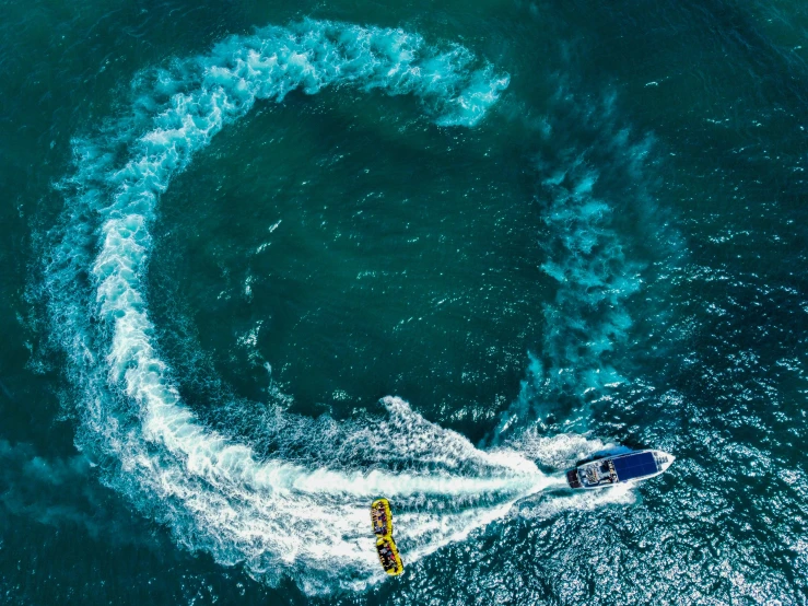 a blue sea boat is riding in front of a circular of blue smoke