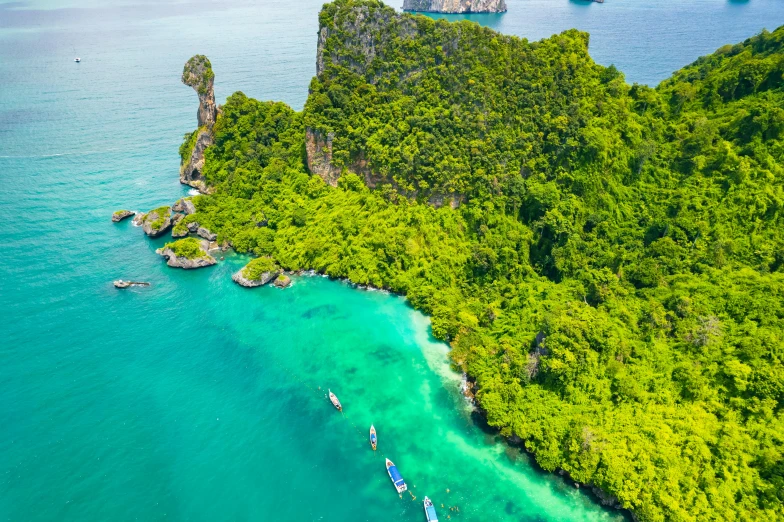 people are floating in boats on the water near an island