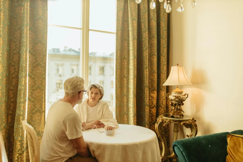 man and woman sitting at round table talking