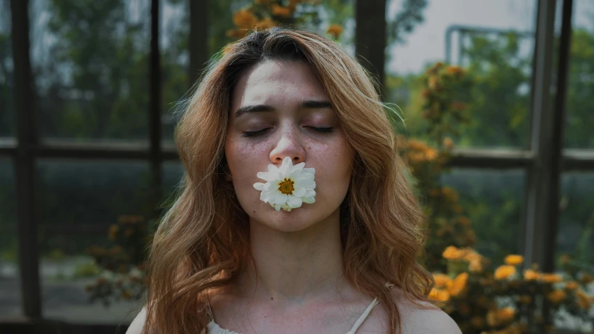 a woman has a flower in her mouth