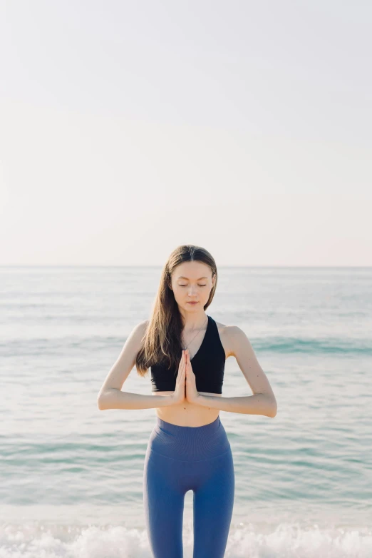 a woman doing yoga on the beach