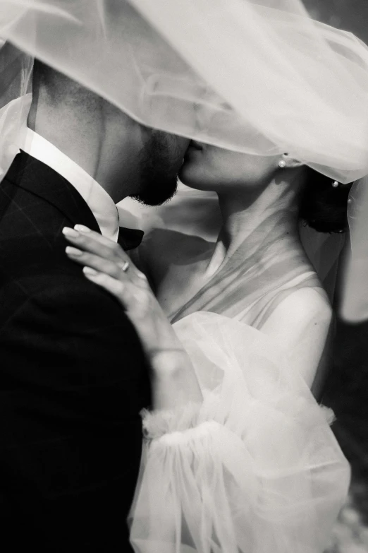 a bride and groom are in love under a veil