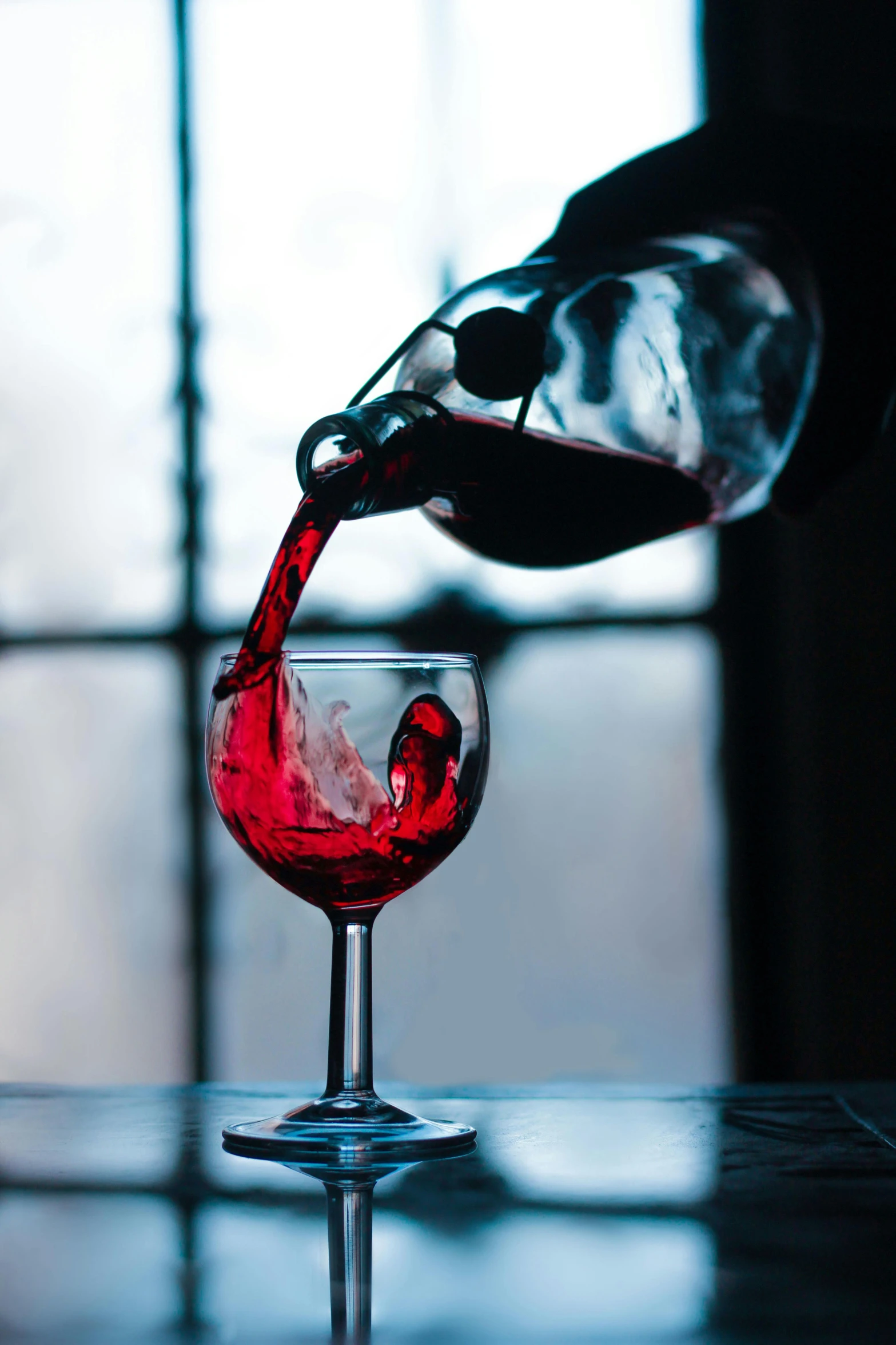 someone pours red wine in a glass