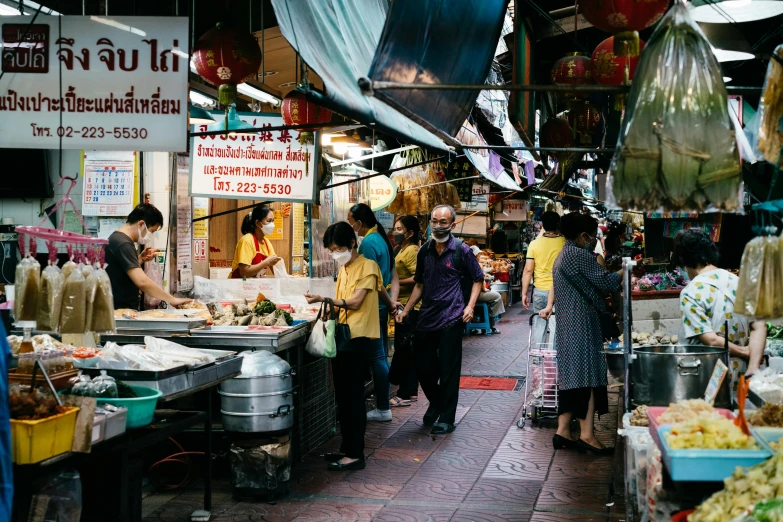 people standing at a food stand on a narrow street