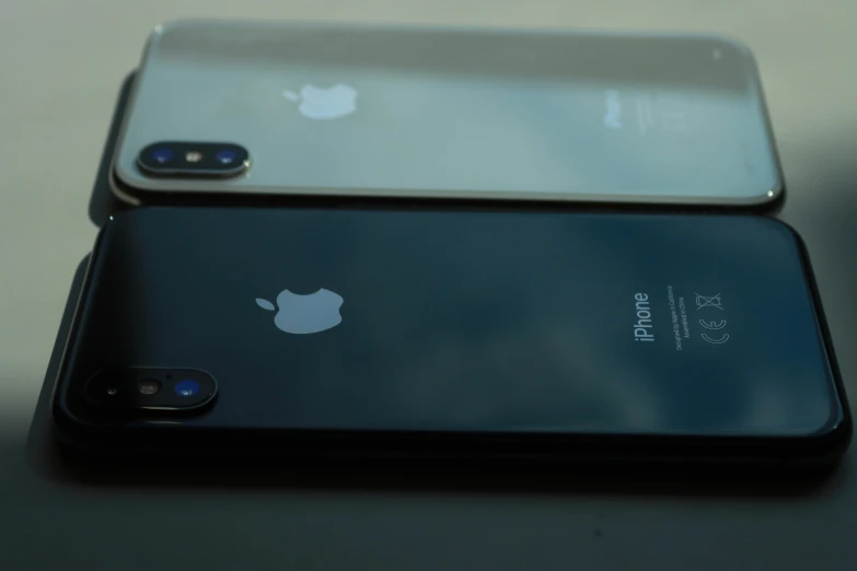 two iphones side by side with apple logo on the back